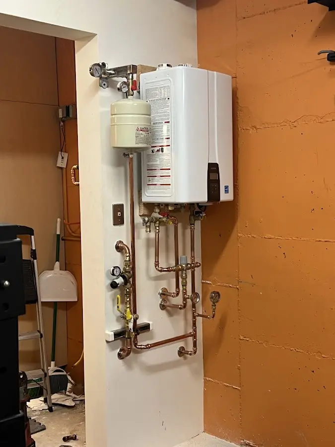 Plumbing technician inspecting water heater connections in Scranton